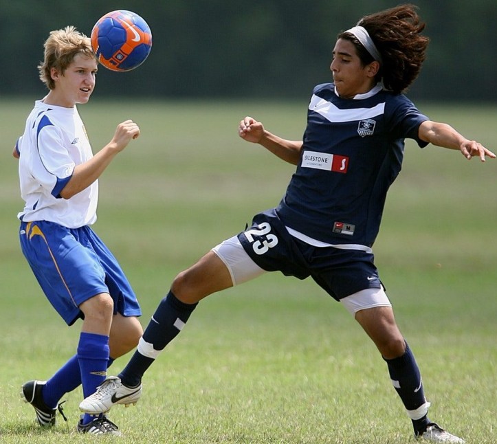 2 niños jugando al futbol