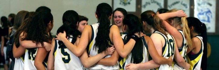 equipo baloncesto abrazado