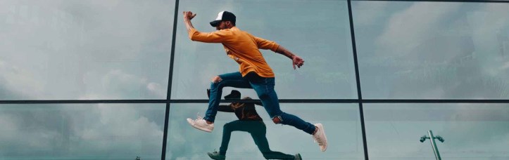 hombre saltando frente a un espejo